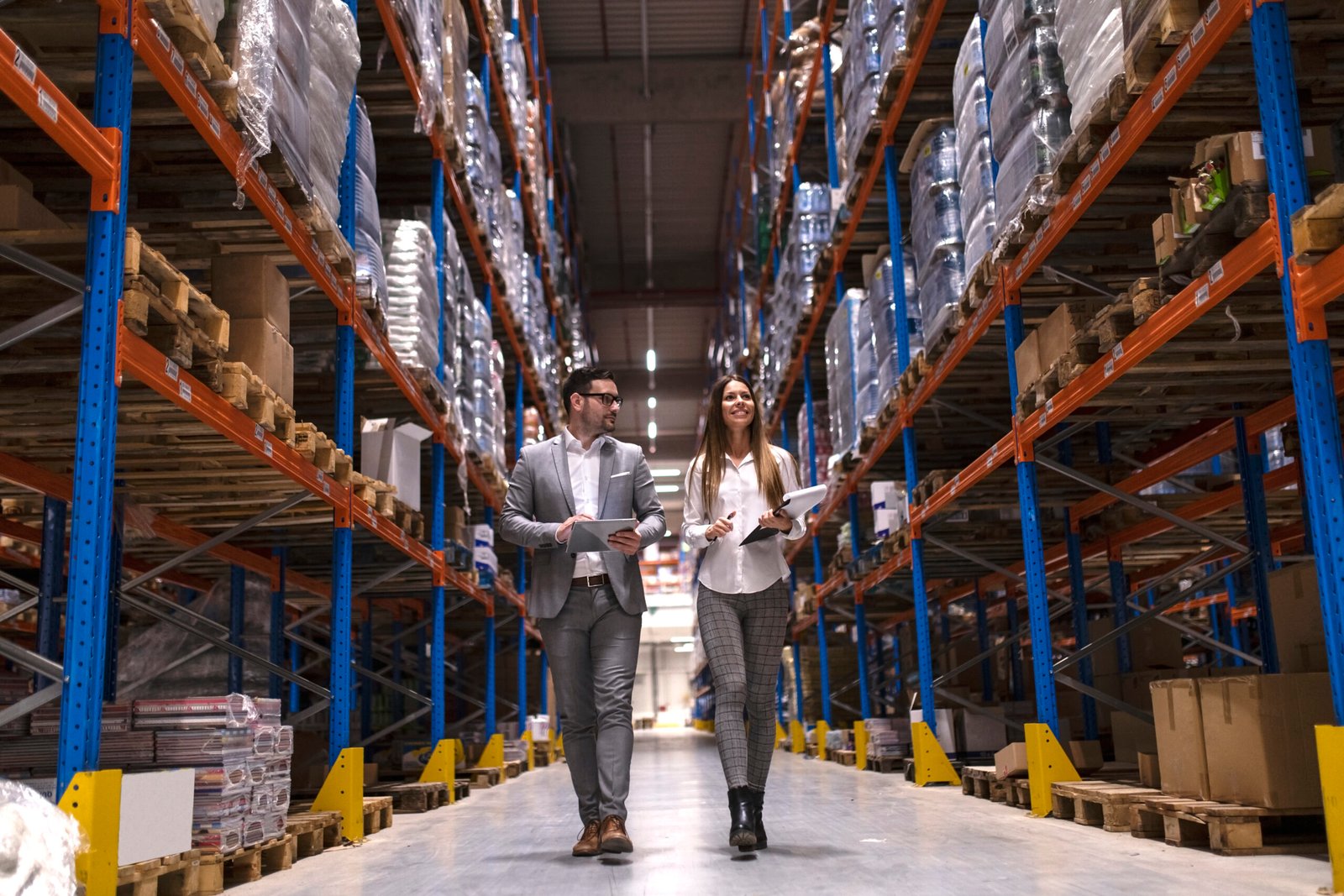 Warehouse managers walking through large distribution center.